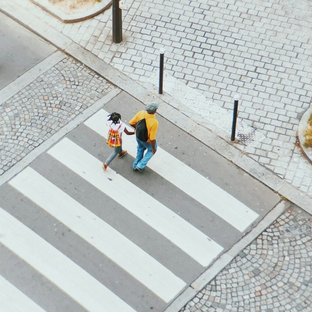 Pedestrians crossing at a busy city crosswalk with traffic nearby